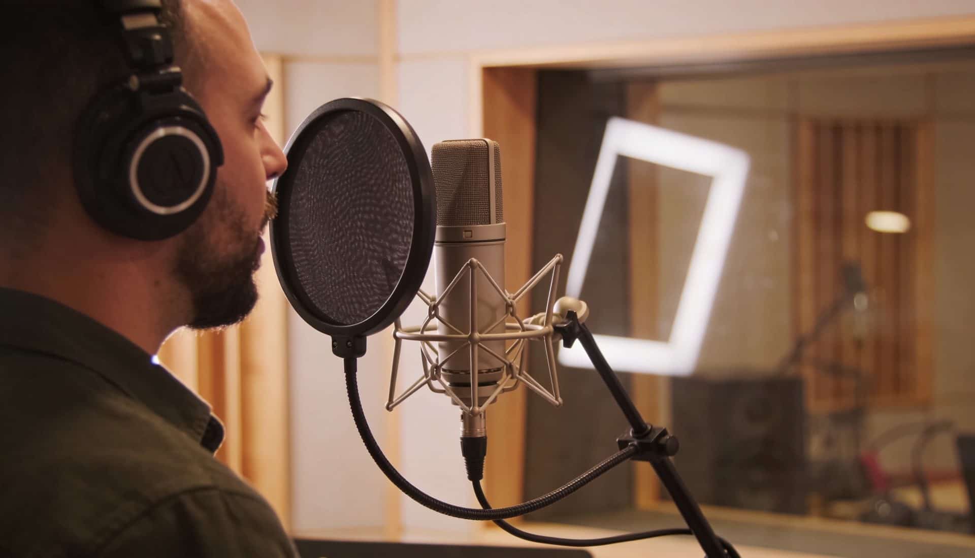 Professional voice actor recording at a studio microphone