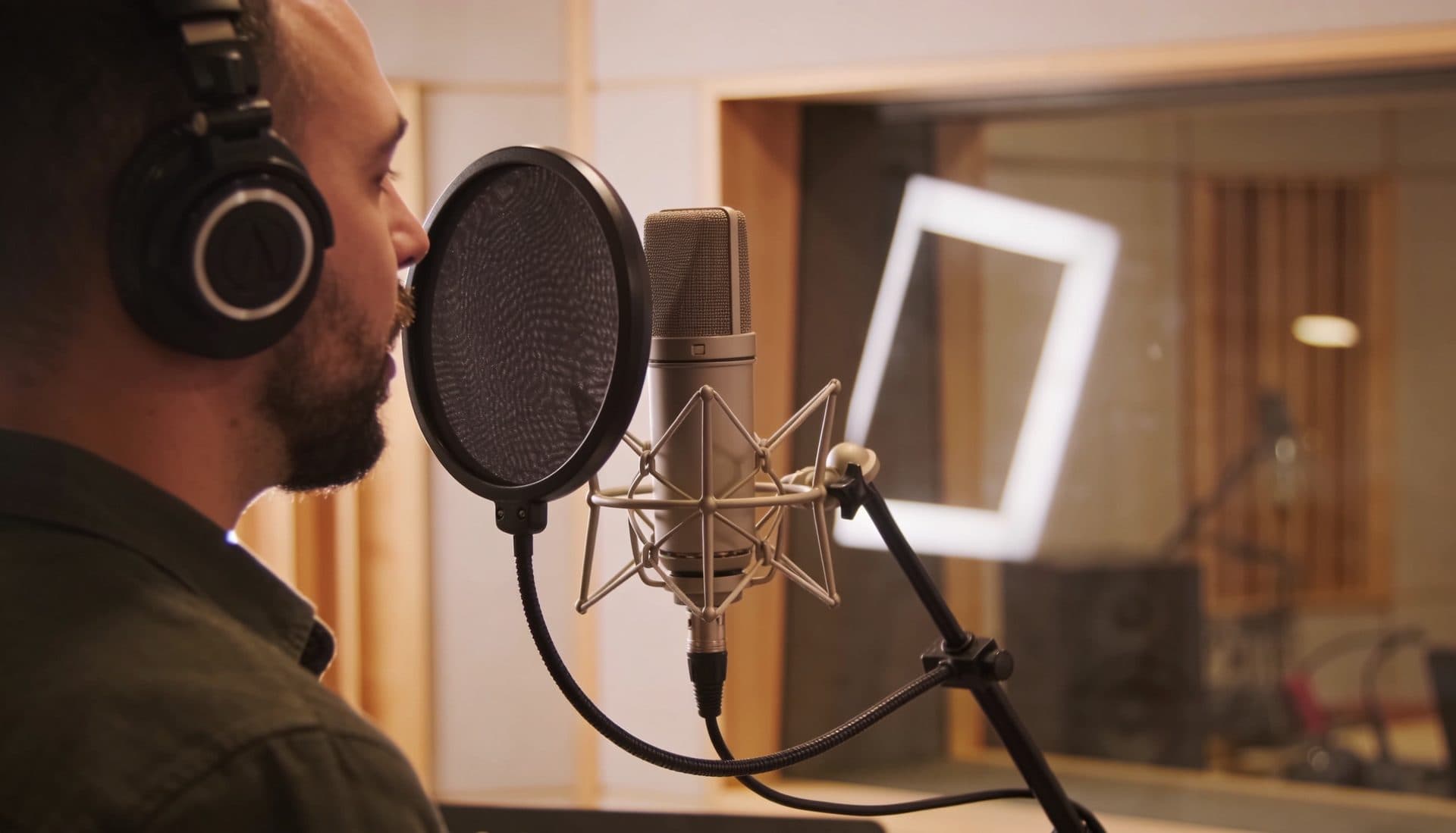 Professional voice actor recording at a studio microphone