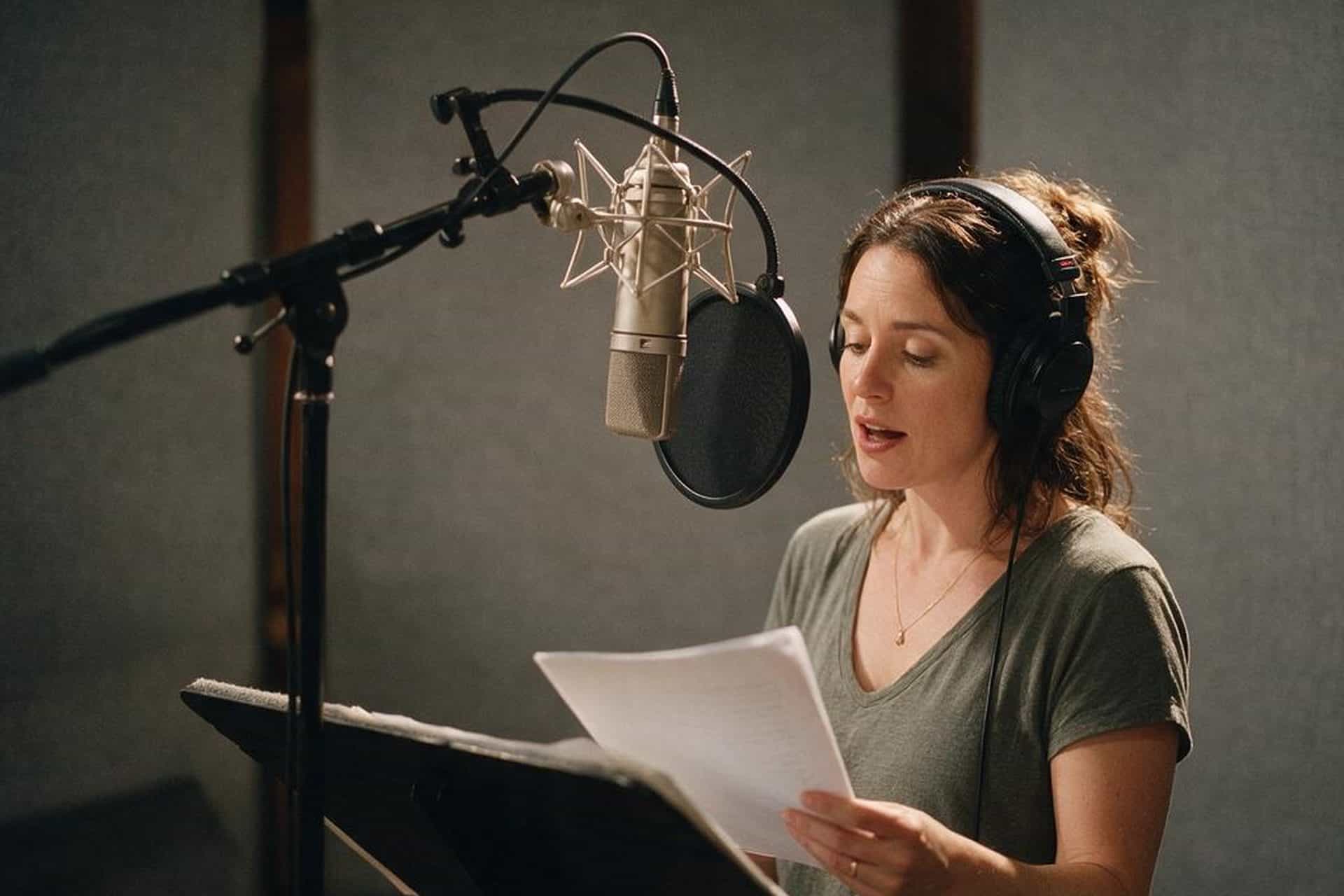 Irish English voice actor recording at a studio microphone in a soundproofed booth