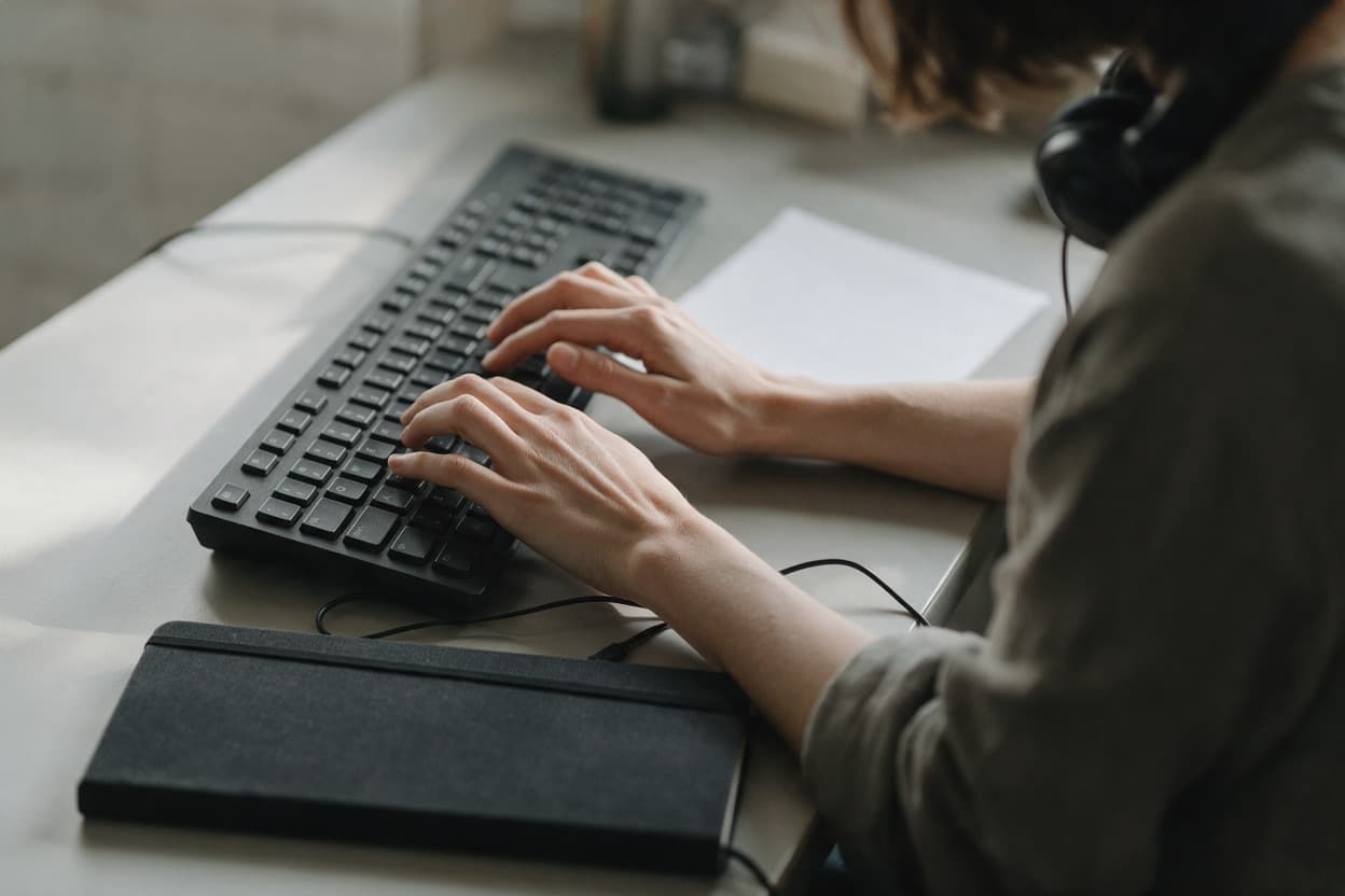 A linguist proofreading a printed transcript against the original recording