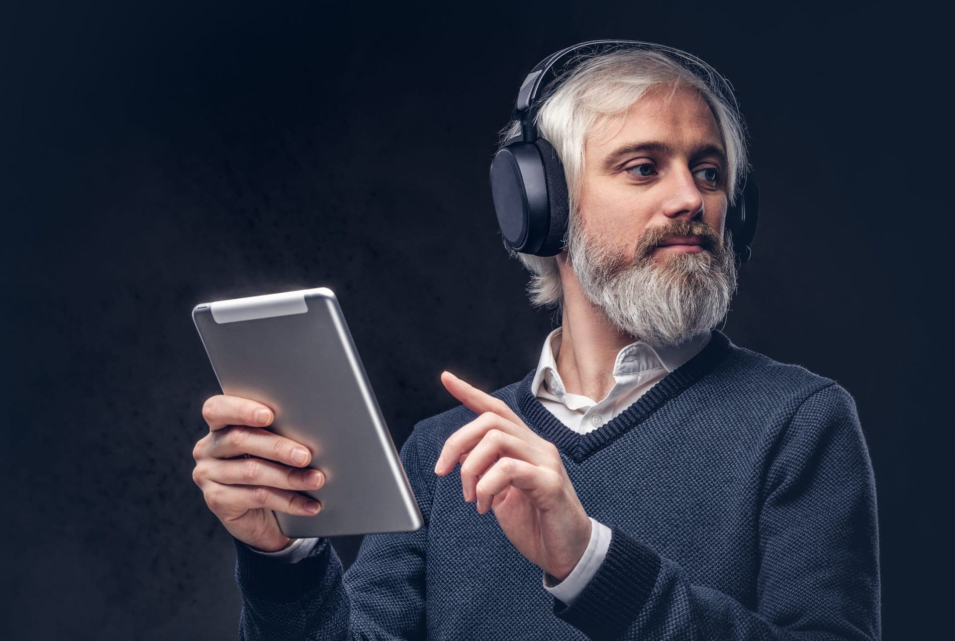 Senior man listening to an audiobook with headphones