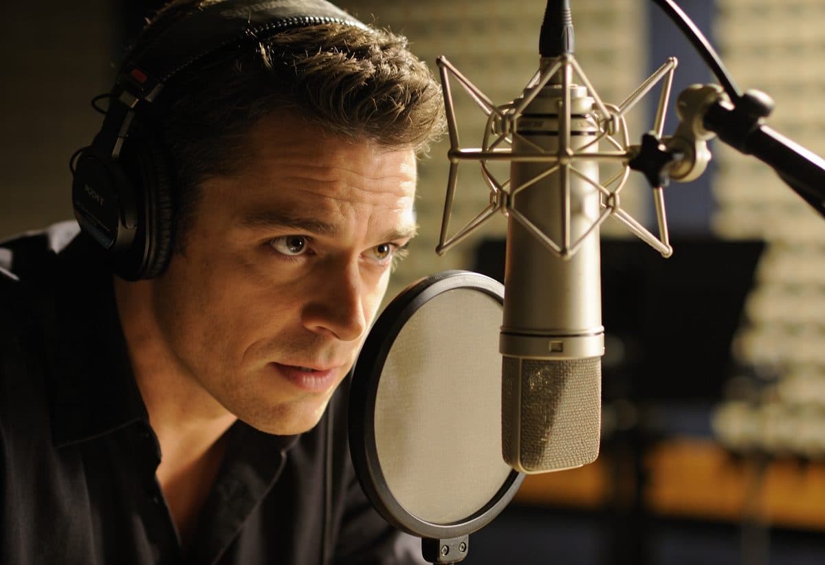 Professional voice actor recording in a sound booth
