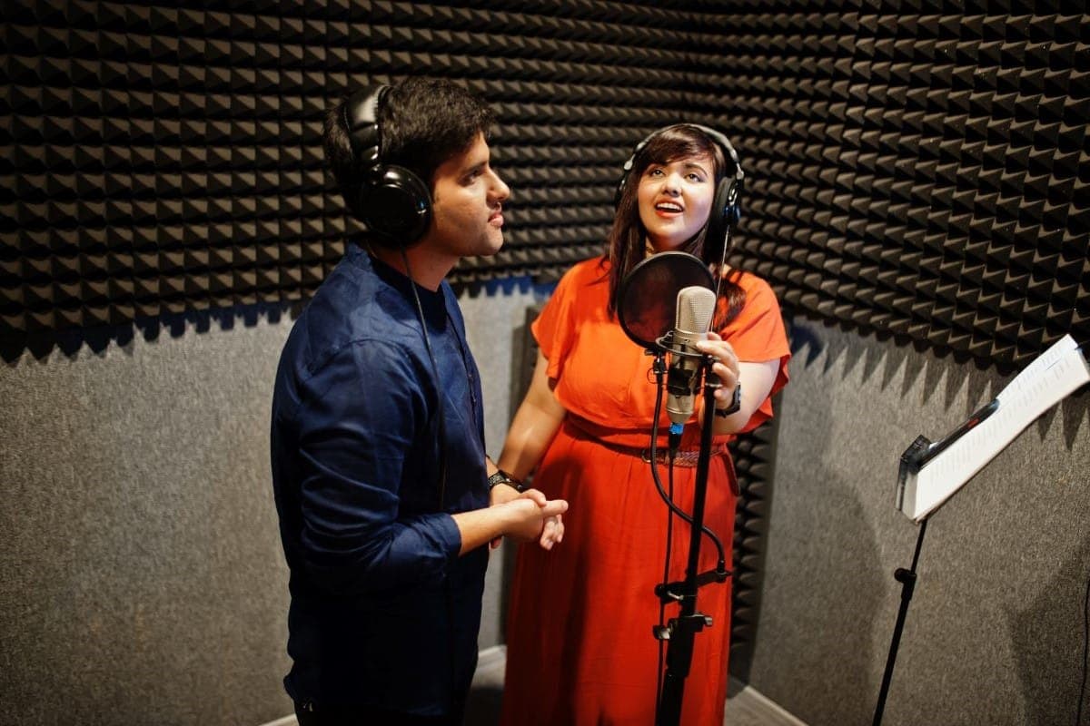Voice actors recording together in a sound booth