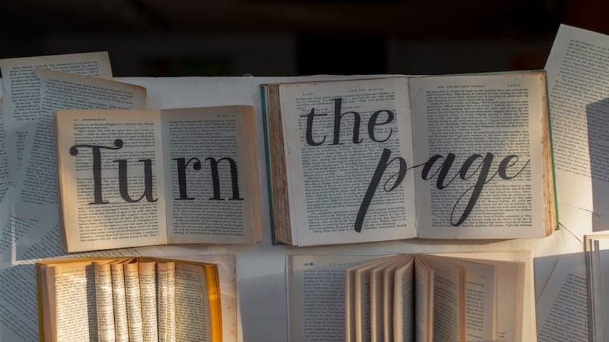 Most Useful Languages to Learn for Translators in 2023 - Pages of books displaying the phrase 'Turn the Page'.