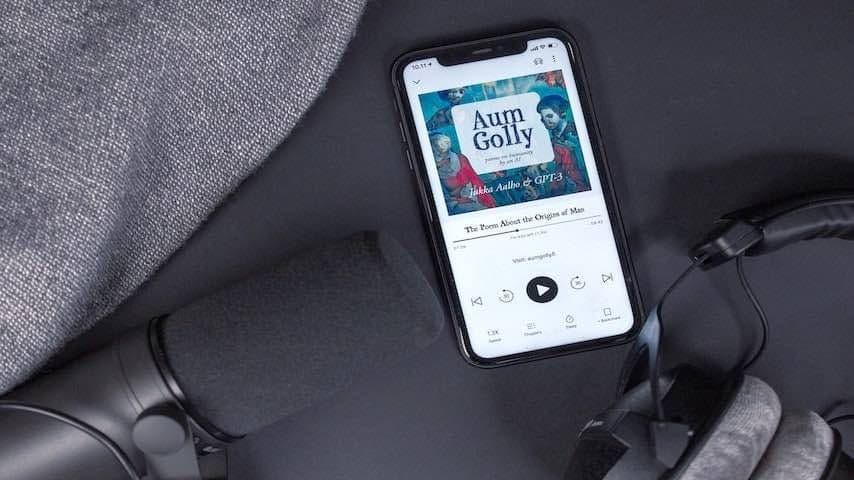 Image of an audiobook with headphones, black phone and microphone on black background and different shades of gray. Used to illustrate an article on Becoming an Audiobook Narrator: A Step-by-Step Guide. Photo by Jukka Aalho on Unsplash: https://unsplash.com/photos/lPAaFIVHvH0