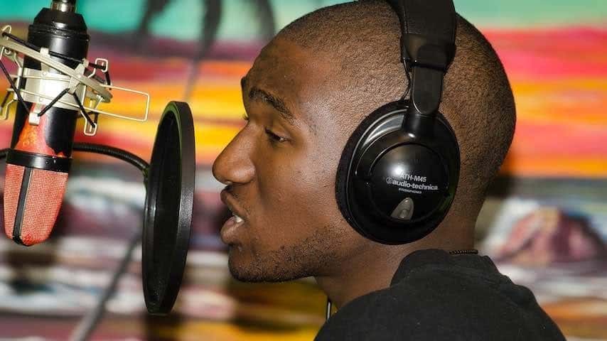 Black person recording vocals in a studio