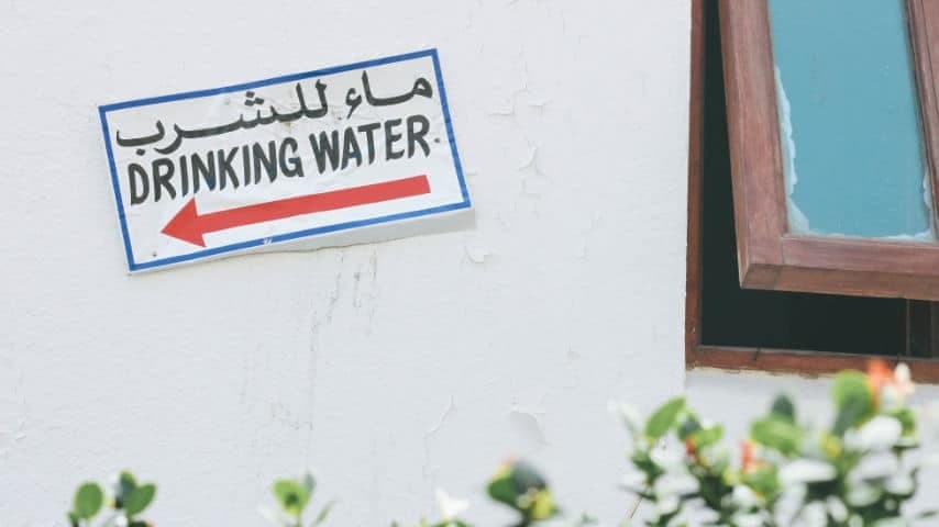 How to Translate English to Arabic Audio and Video. Sign on a wall saying "drinking water" in English and Arabic. Photo by Olivia Hutcherson at Unsplash. Unsplash License. https://unsplash.com/es/fotos/7to7gDInYns