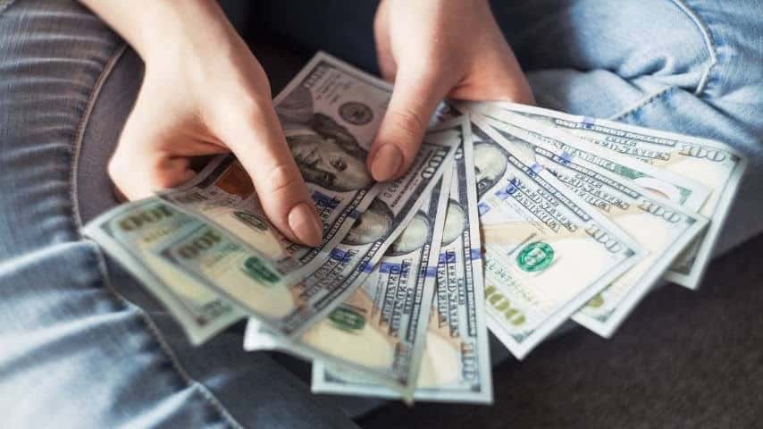 How Much Do Voice Actors Make? Photo of the Hands of a woman holding 100 dollar bills by