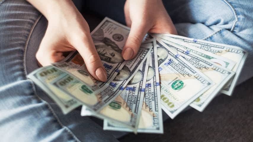 How Much Do Voice Actors Make? Photo of the Hands of a woman holding 100 dollar bills by