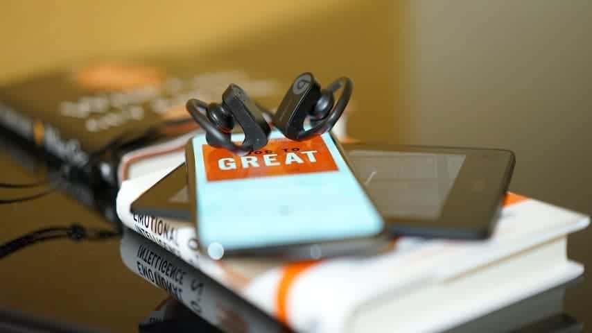 Unabridged Audiobook. Image of book with a tablet, smartphone and earphones. This image is used to illustrate the article "Abridged vs Unabridged Audiobooks: Which One Should You Choose?". Unsplash license: https://unsplash.com/photos/2ALQUTD5MKc