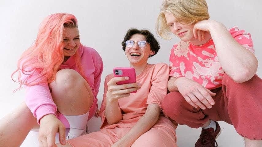 Friends in pink clothes looking at a smartphone