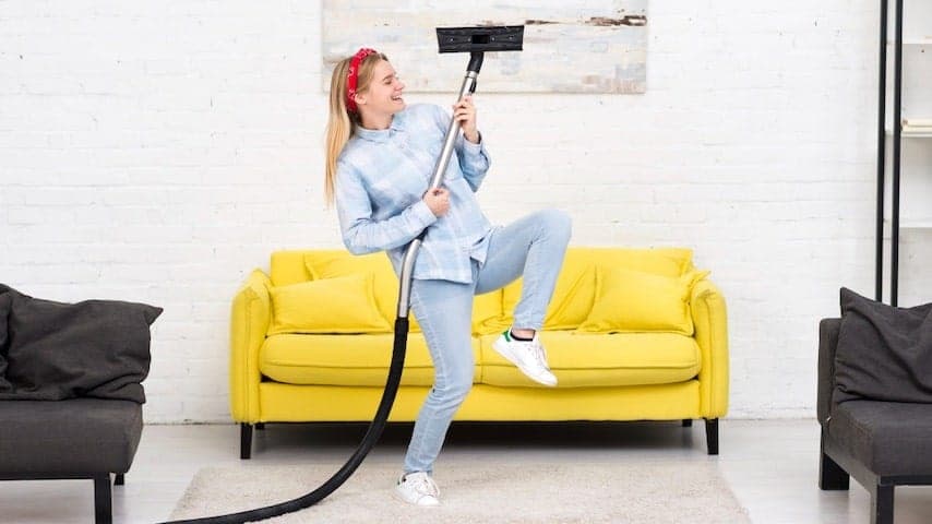 A woman doing house chores with a vacuum