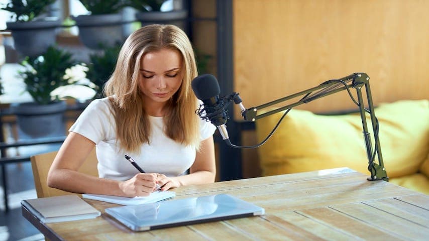 How to write a tv commercial script. Photo of a beautiful woman writing some information in notebook. This image is used to illustrate the article “How to Write a TV Commercial Script - Expert Insights.” Freepik license: https://www.freepik.com/free-photo/beautiful-woman-writing-some-information-notebook_13533945.htm