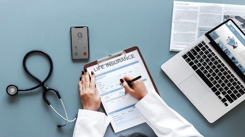 A doctor filling up a life insurance form