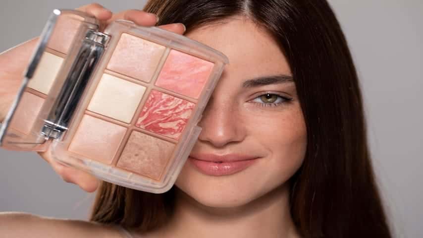 Young woman portrait holding a makeup product
