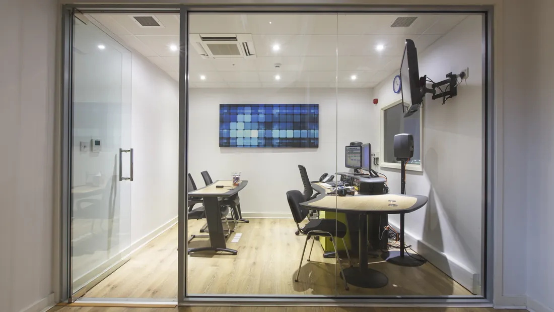 Blue Studio booth seen through the control room glass