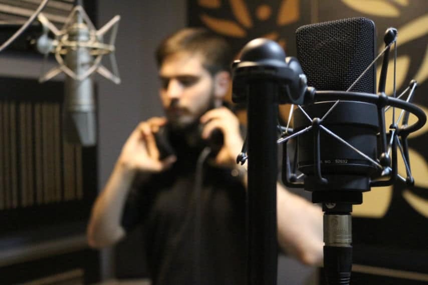 Man doing lip sync like in a professional recording studio. Foto de Foto de Amin Asbaghipour in Unsplash, https://unsplash.com/es/fotos/Vn3MBnZ5fdE