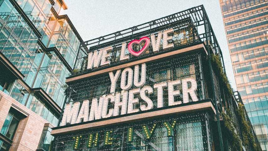 Neon sign reading We Love You Manchester on a Manchester building