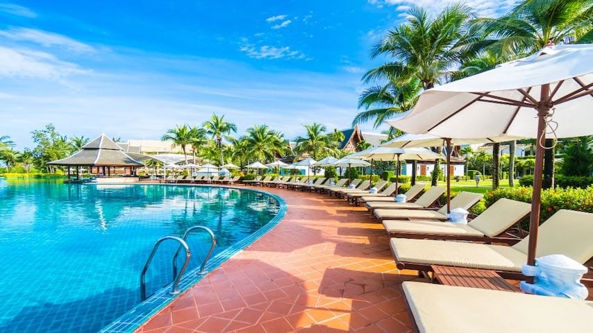 Hammocks and umbrella placed near a large pool